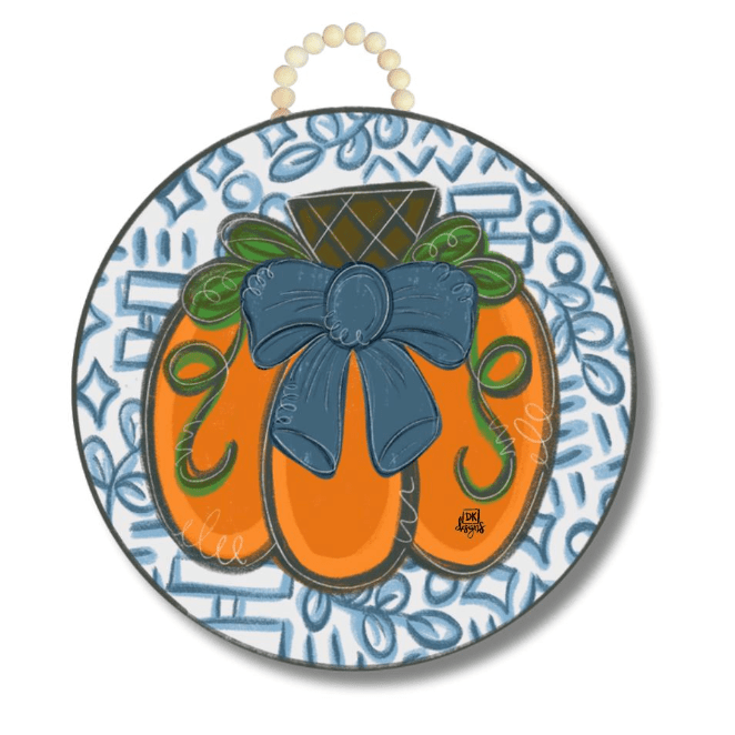 Decorative door hanger with orange pumpkin and a blue bow on a patterned background