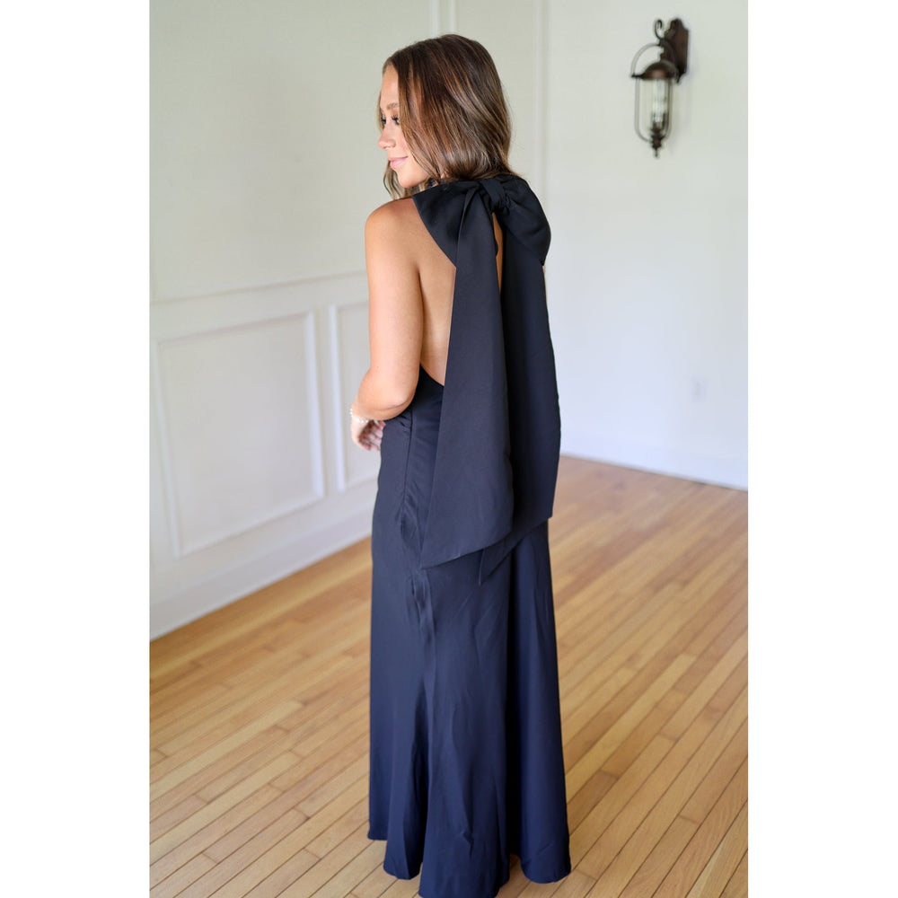 Woman wearing a black dress with a bow detail 