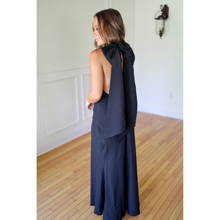 Woman wearing a black dress with a bow detail 