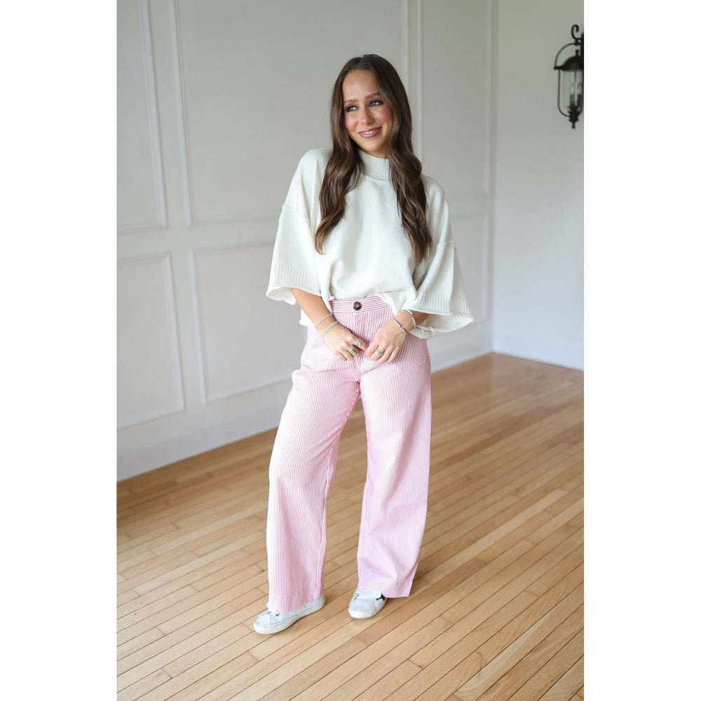 Woman wearing a white top and red pants 