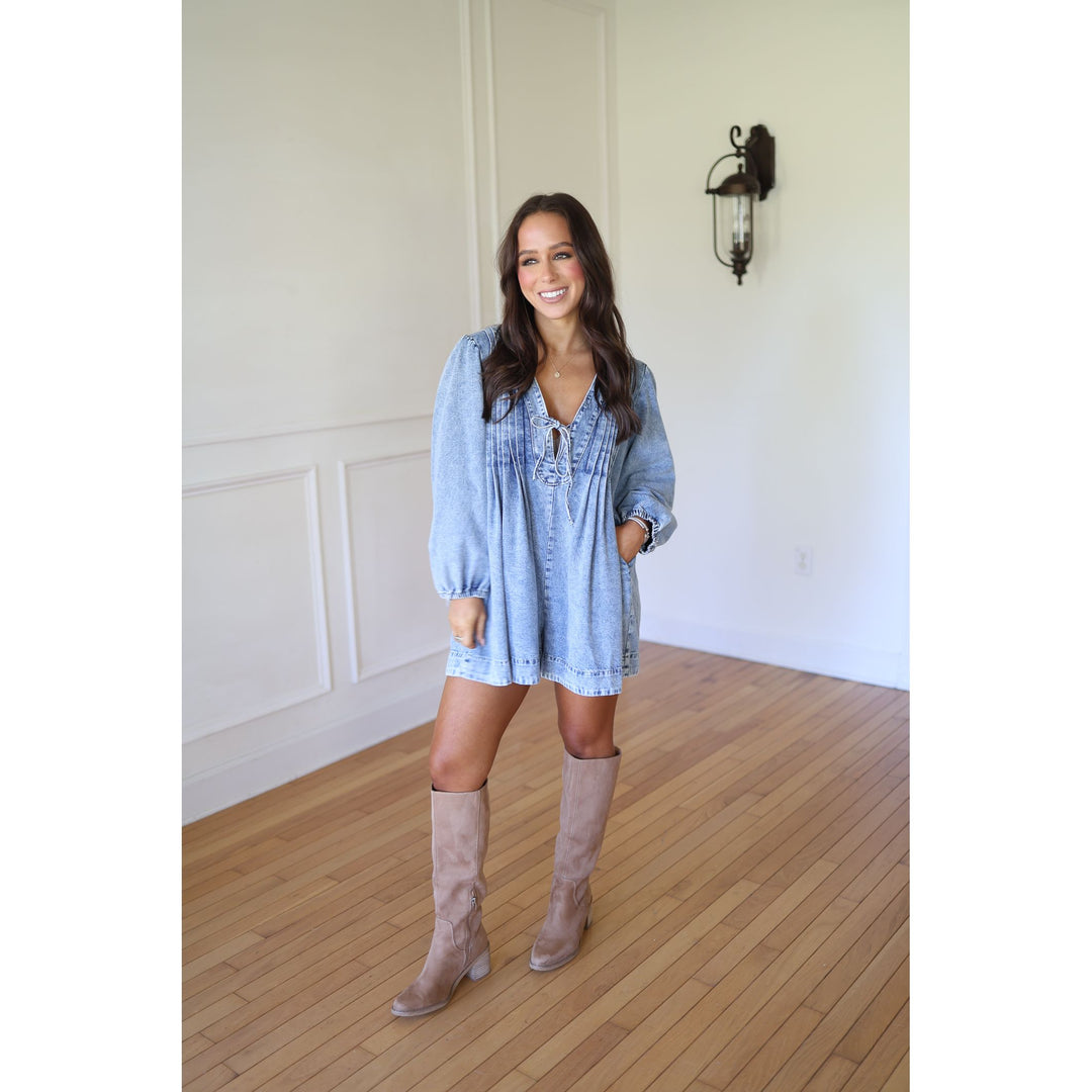 Woman wearing a blue dress and beige knee-high boots 