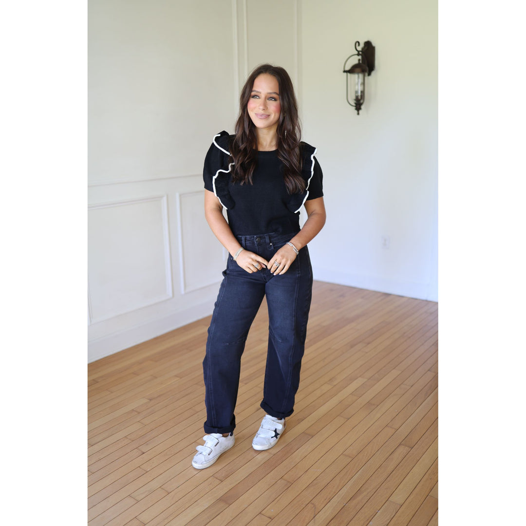 Woman wearing a black outfit with white accents 