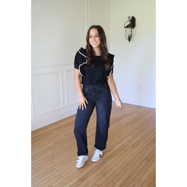 Woman wearing a black top and blue jeans 