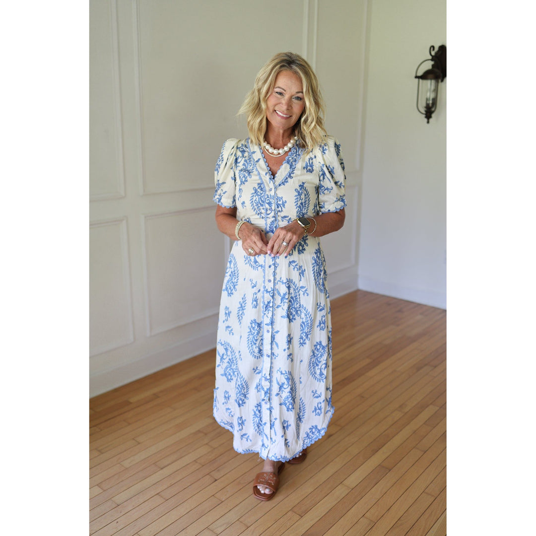 Woman wearing a white dress with blue floral patterns 