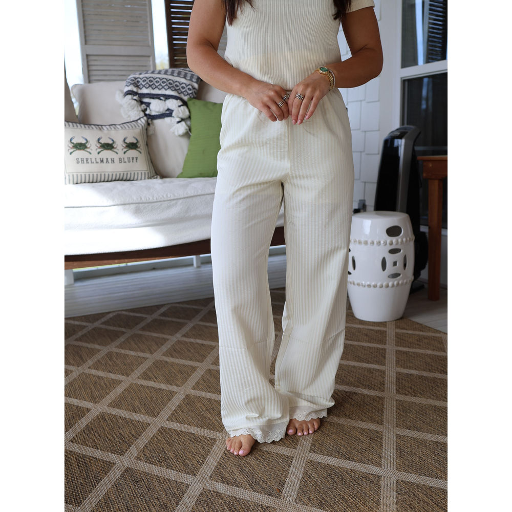 Person wearing a white ribbed outfit in a living room setting