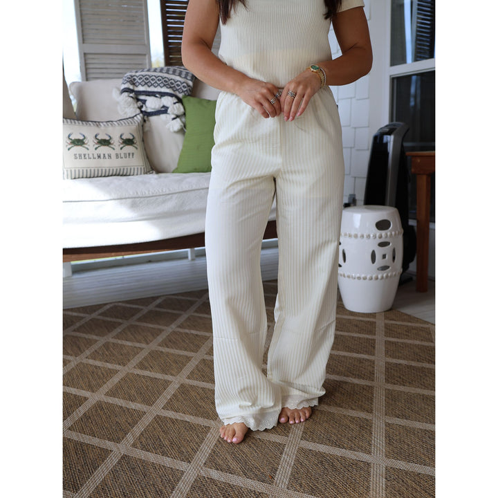 Person wearing a white ribbed outfit in a living room setting