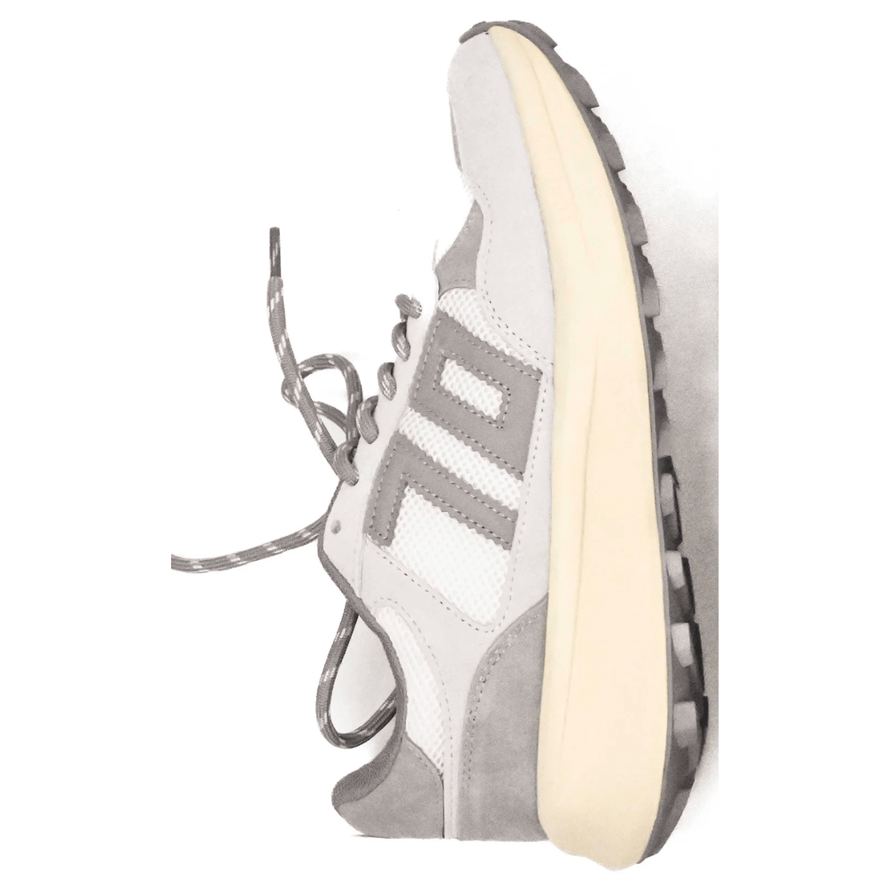 Gray and white sneaker with a visible brand logo on a white background
