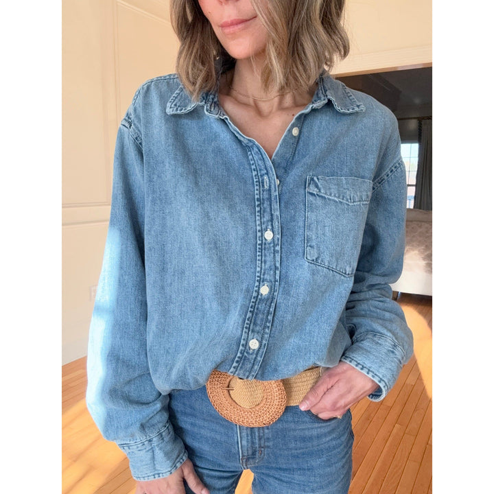 Person wearing a denim shirt a woven belt