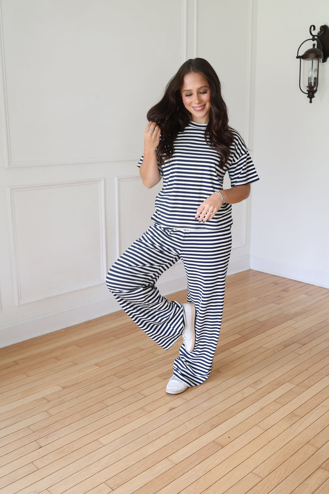 A woman modeling a matching two-piece loungewear set with navy and white horizontal stripes, consisting of a short-sleeve crewneck top and wide-leg pants7