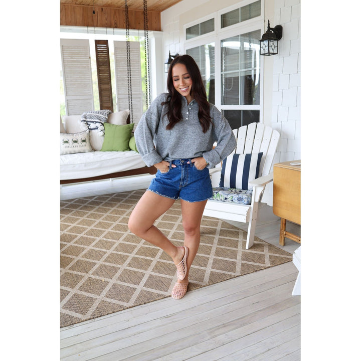 woman wearing gray sweater and denim shorts