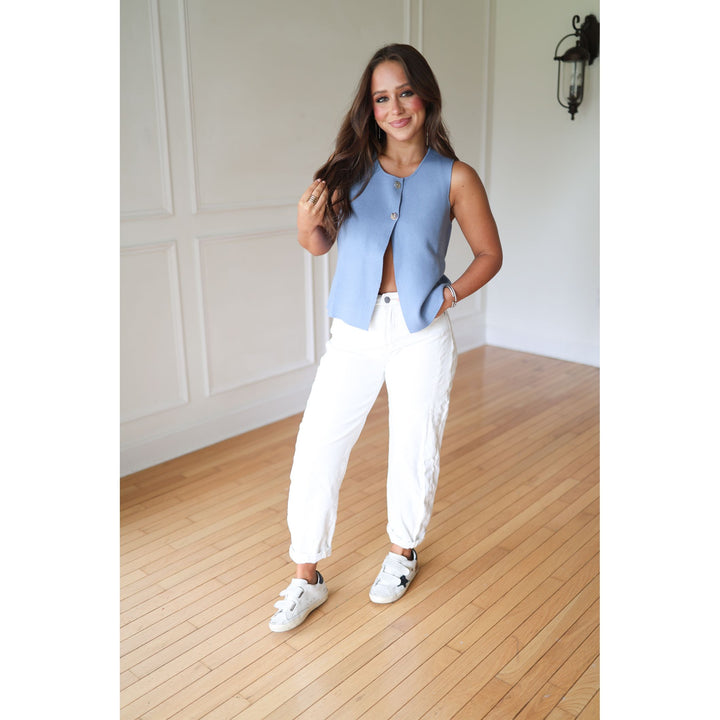 Woman wearing a blue vest and white pants 