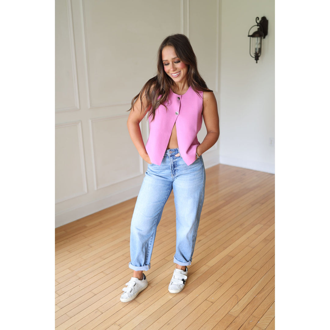 Woman wearing a pink vest and blue jeans 