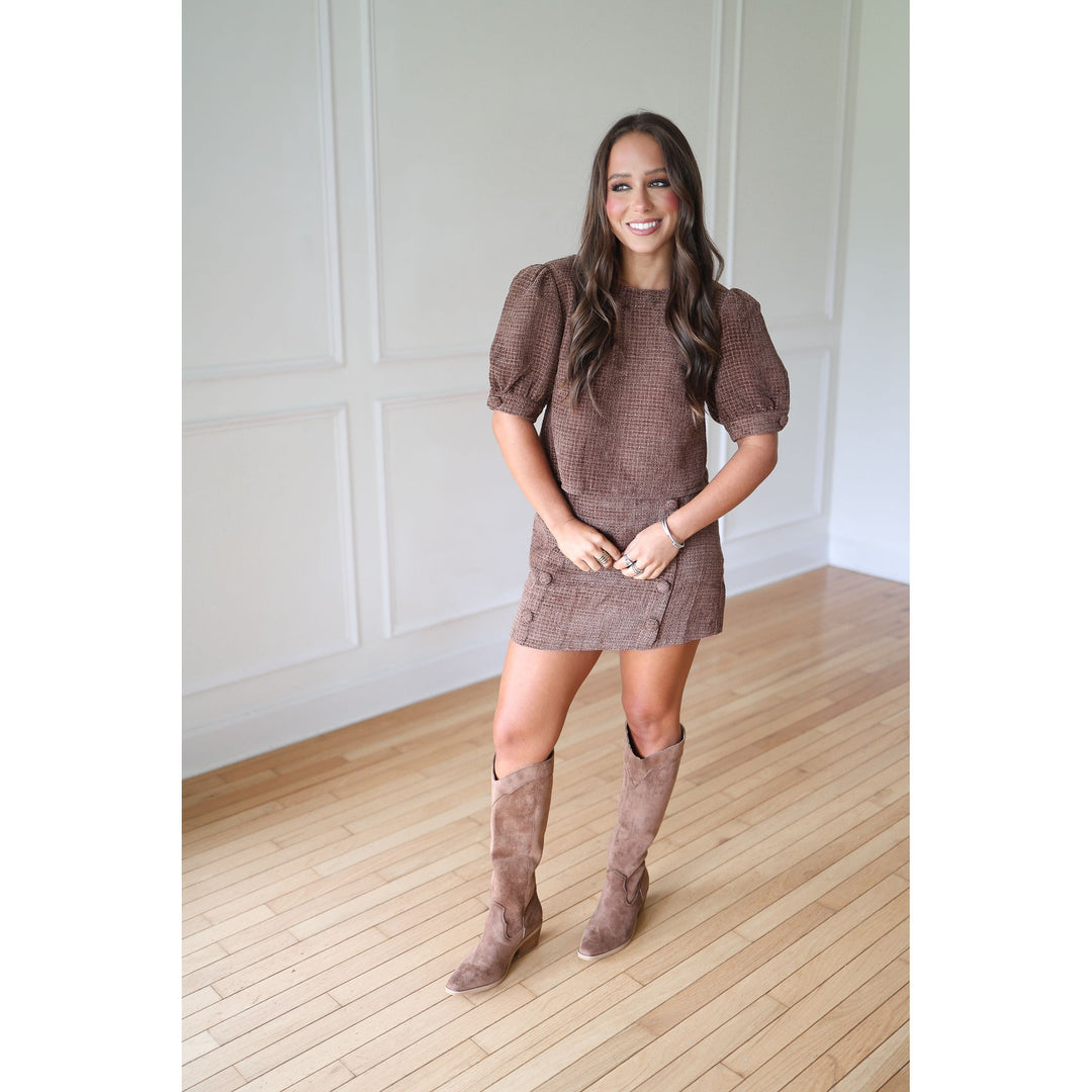 Woman wearing a brown set and knee-high boots 