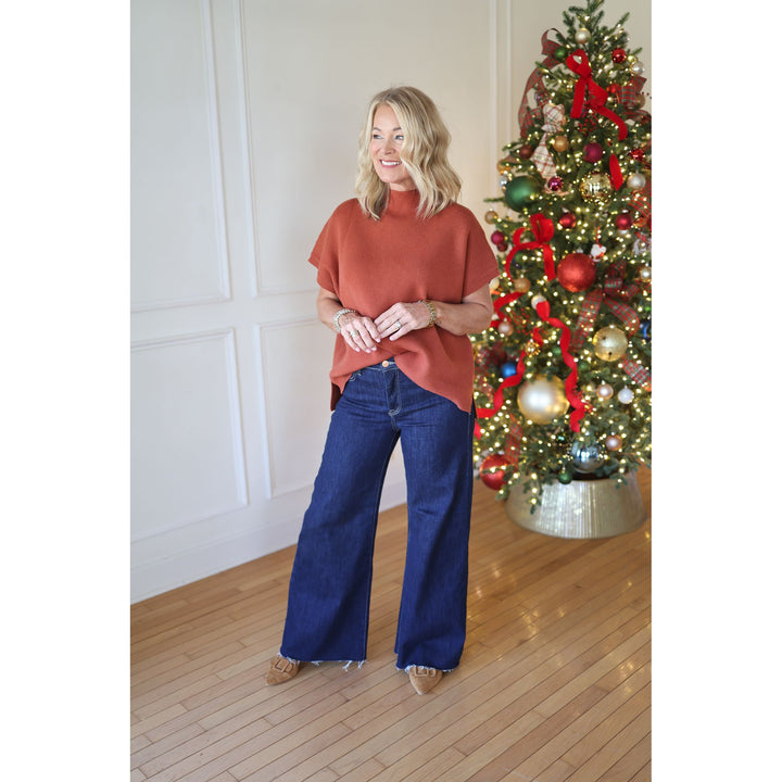 woman wearing rust sweater and jeans