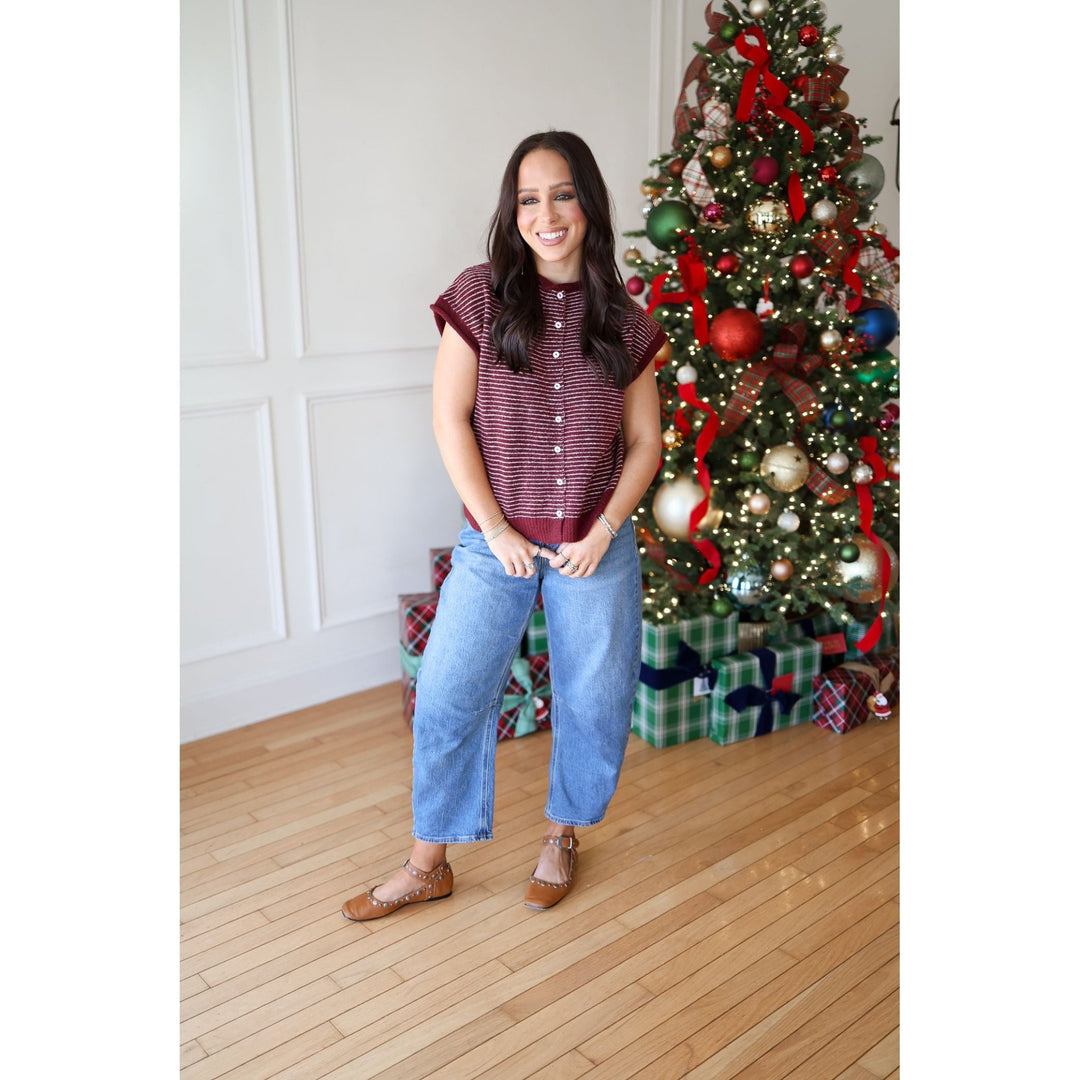 Woman standing in front of a decorated Christmas tree indoors.