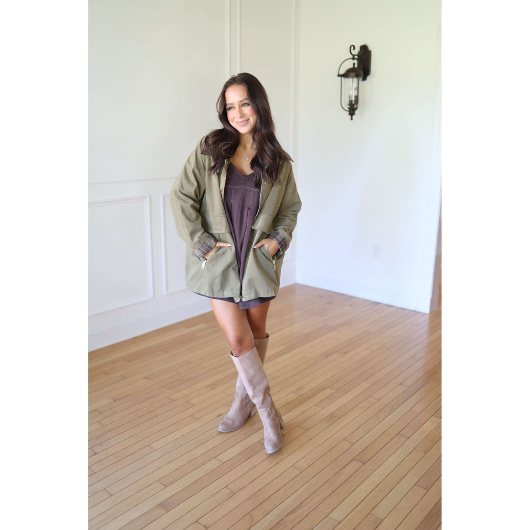 Woman wearing a green jacket and beige boots 