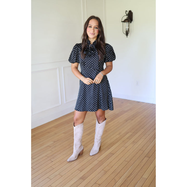 Woman in a polka dot dress and white knee-high boots 