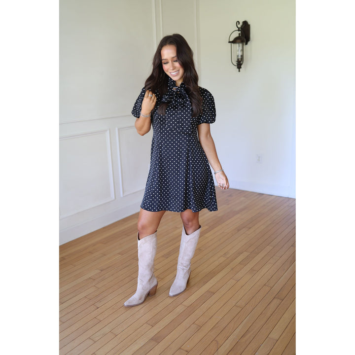 Woman in a polka dot dress and white knee-high boots 