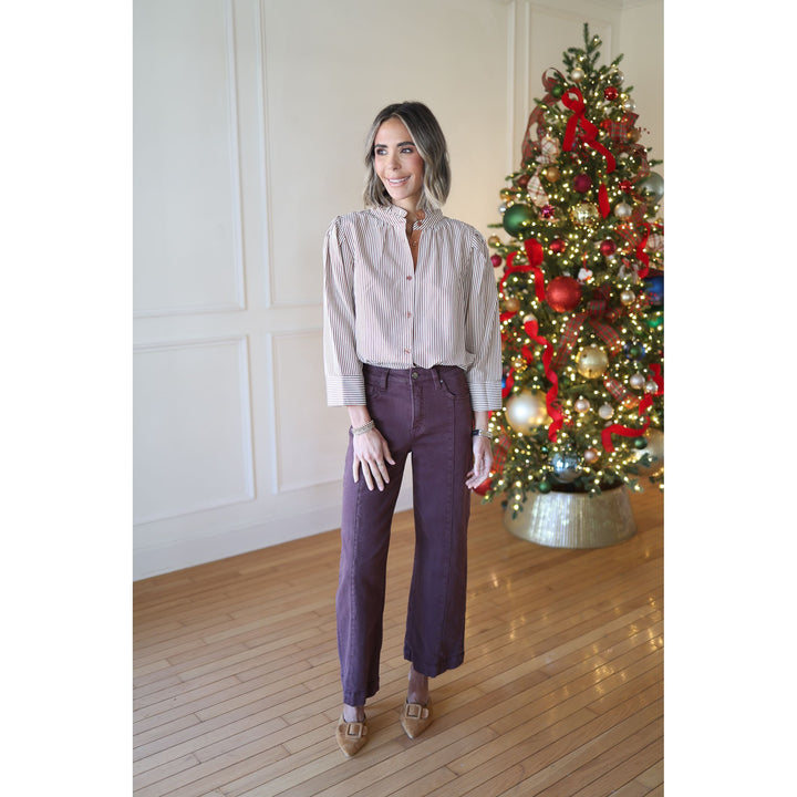 Woman standing in front of a decorated Christmas tree indoors.