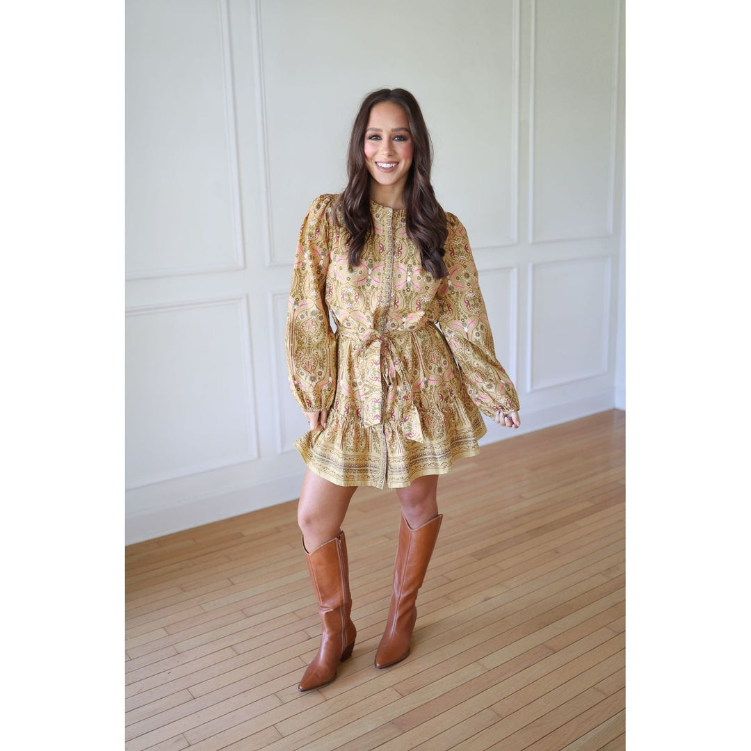 Woman wearing a floral dress and brown knee-high boots 