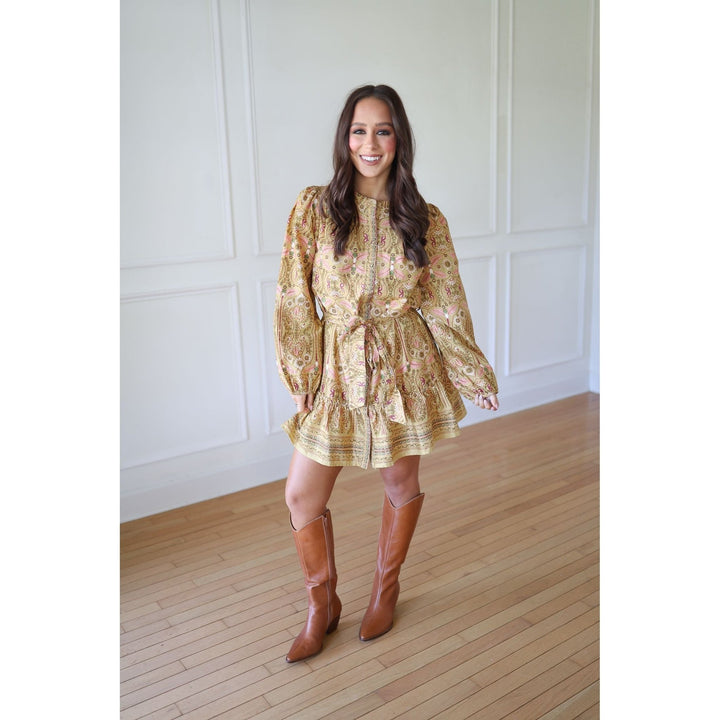 Woman wearing a floral dress and brown knee-high boots 