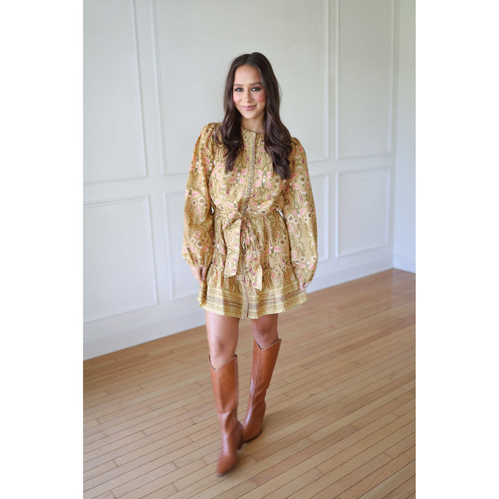 Woman wearing a floral dress and brown knee-high boots 