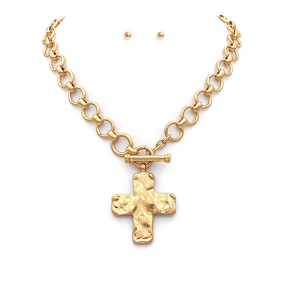 Gold chain necklace with a hammered cross pendant and a small matching stud earring.