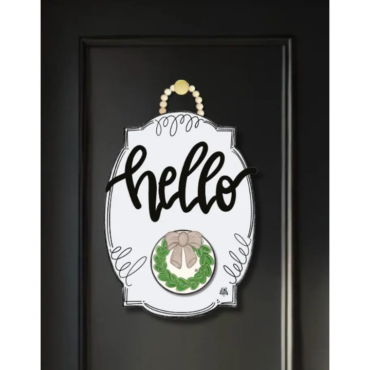 Decorative door sign with 'hello' text and wreath design on a black background