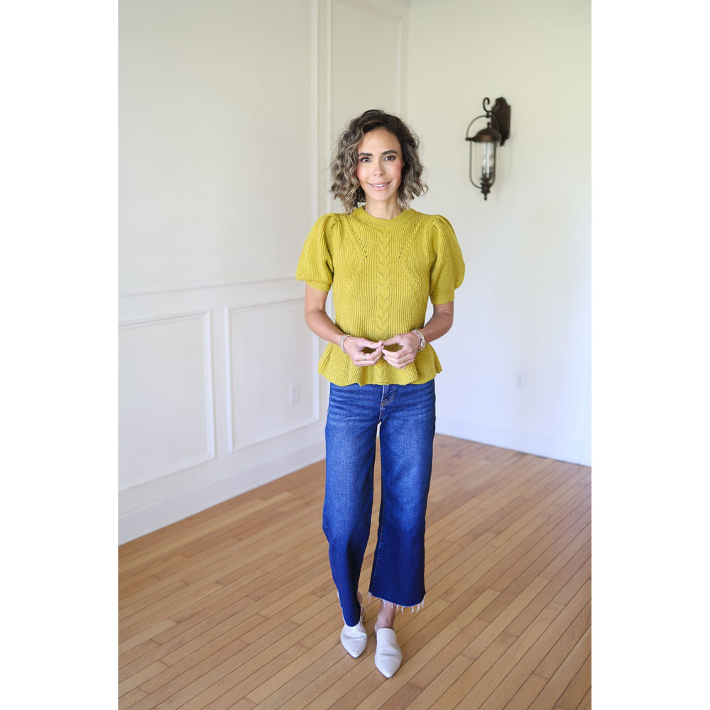 Woman wearing a chartreuse top and blue jeans 
