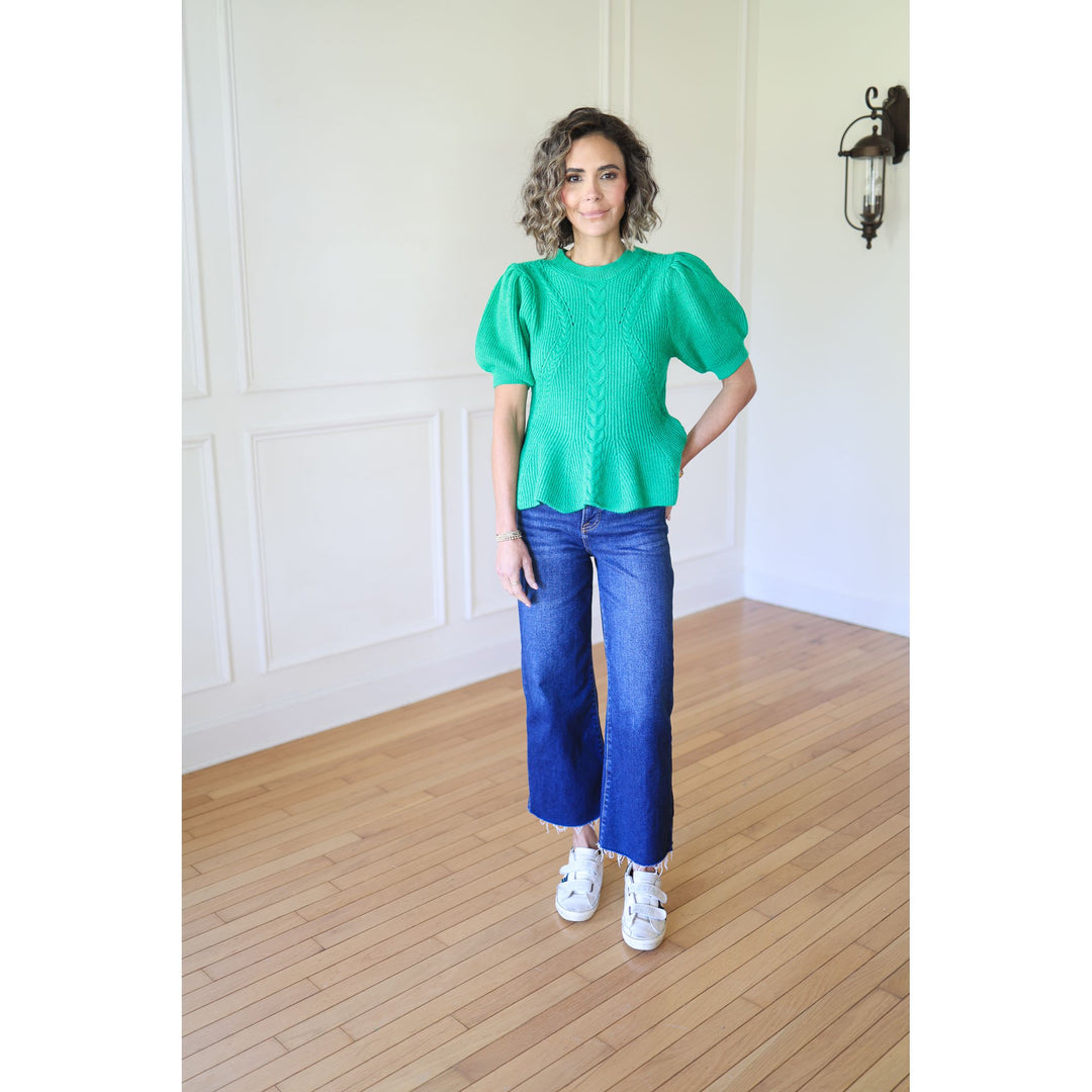 Woman wearing a green top and blue jeans 