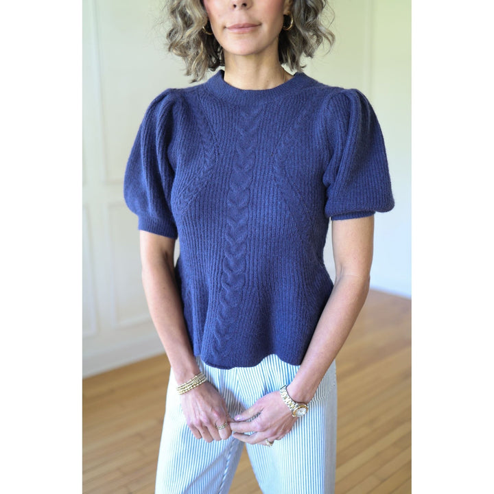 Woman wearing a blue knitted sweater with puffed sleeves i
