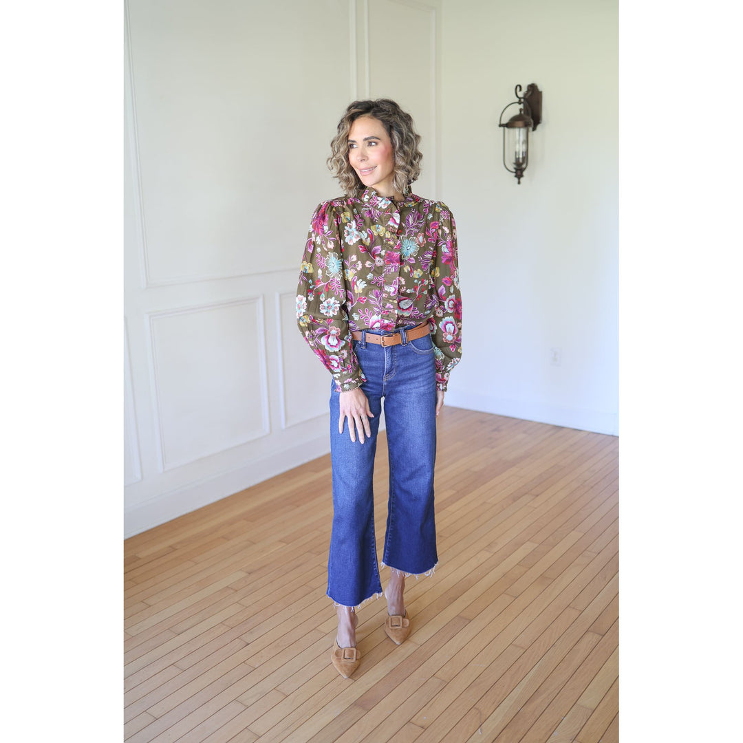 Woman wearing a floral blouse and blue jeans 