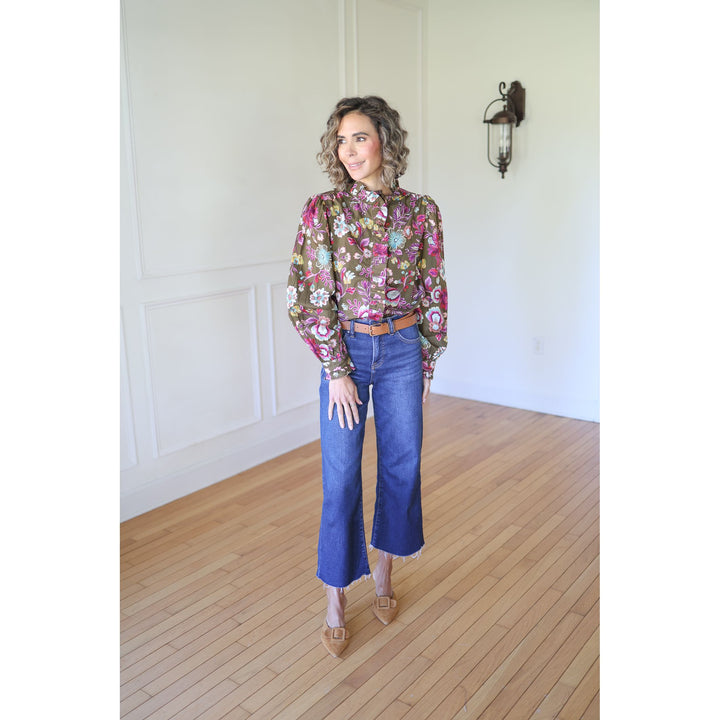 Woman wearing a floral blouse and blue jeans 