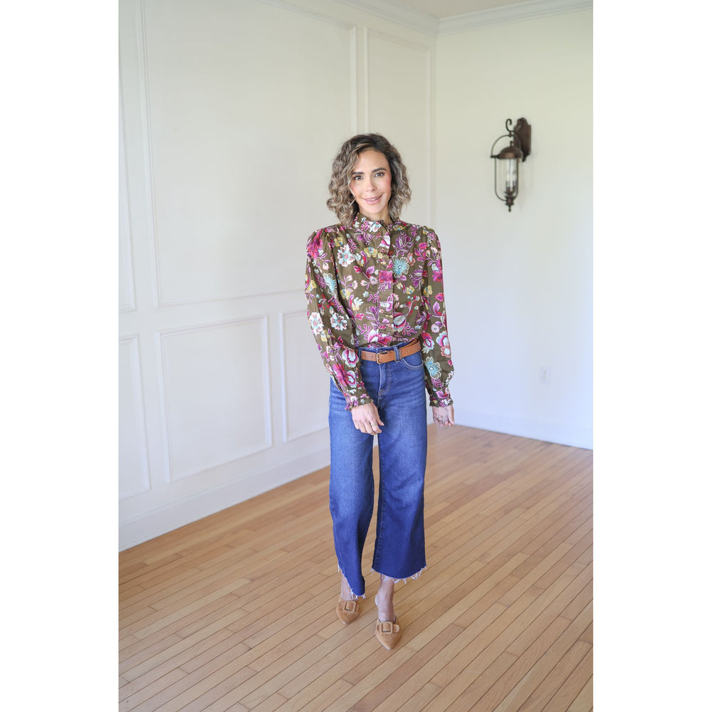 Woman wearing a floral blouse and blue jeans 