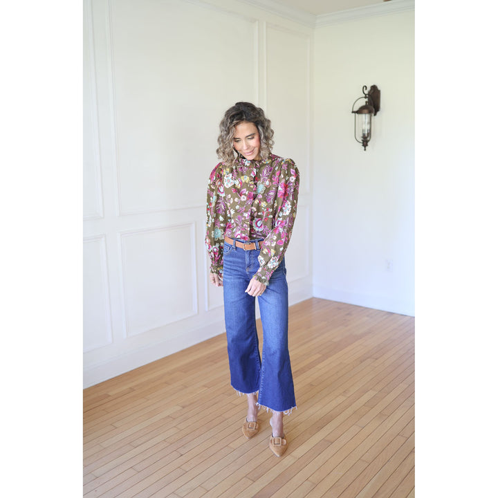 Woman wearing a floral blouse and blue jeans