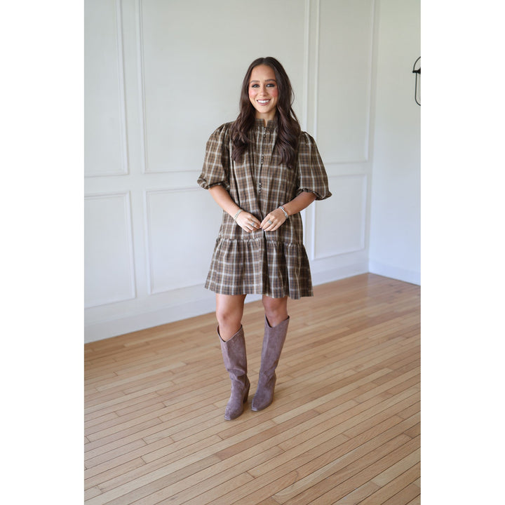 Woman wearing a plaid dress and gray boots 