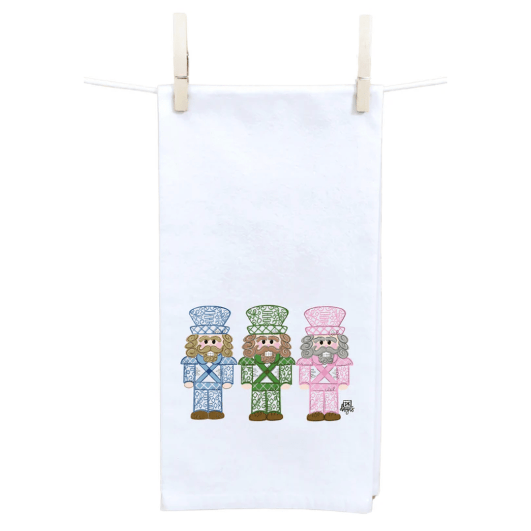 White towel with embroidered nutcracker design hanging on a clothesline.