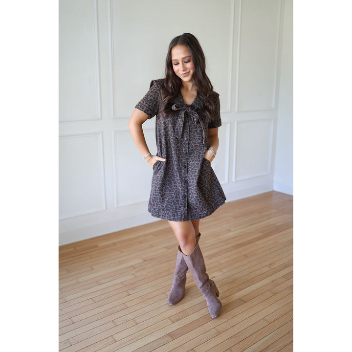 Woman wearing a patterned dress and knee-high boots 