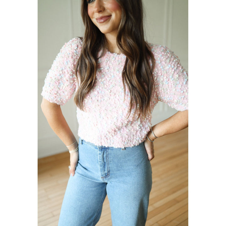 Woman wearing a pink sweater and blue jeans 