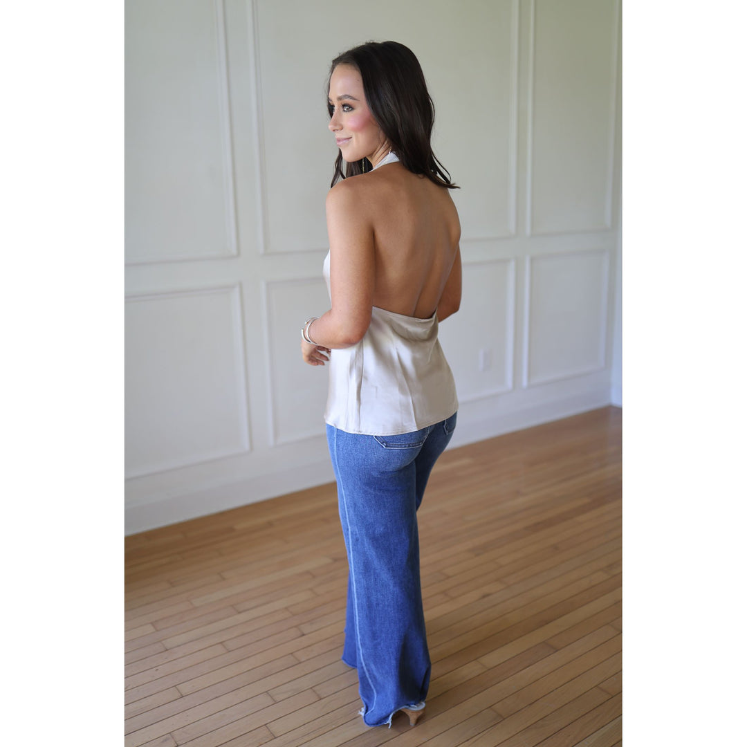 Woman wearing a champgane top and blue jeans s