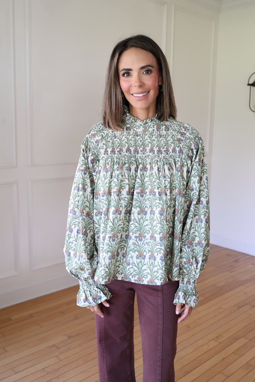 woman wearing a floral top and brown denim