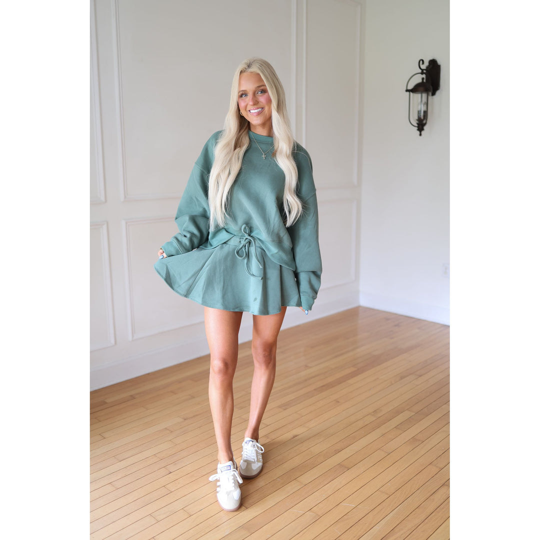 Woman wearing a teal skirt and sweatshirt
