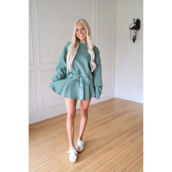 Woman wearing a teal skirt and sweatshirt