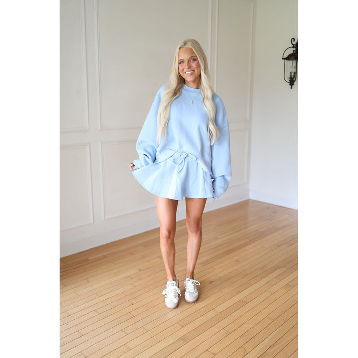Woman wearing a light blue oversized sweater and skort