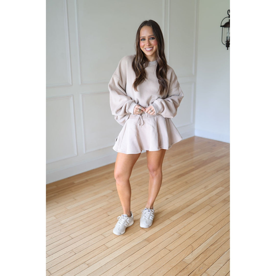Woman wearing a mocha sweatshirt and skort