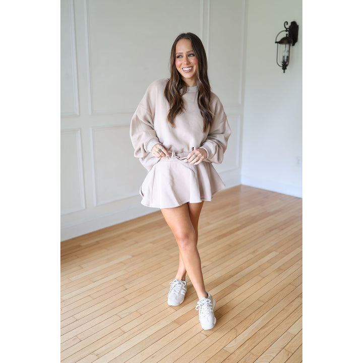 Woman in a mocha sweatshirt and skort