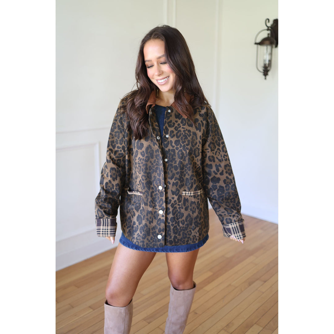 Woman wearing a leopard print jacket with plaid sleeves 