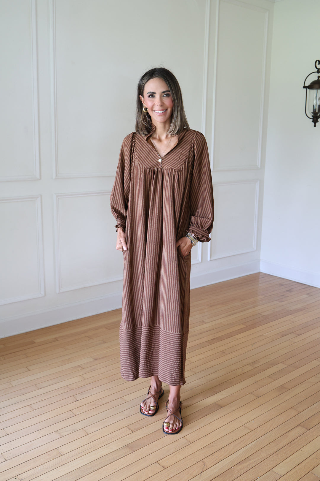 woman wearing brown striped maxi dress