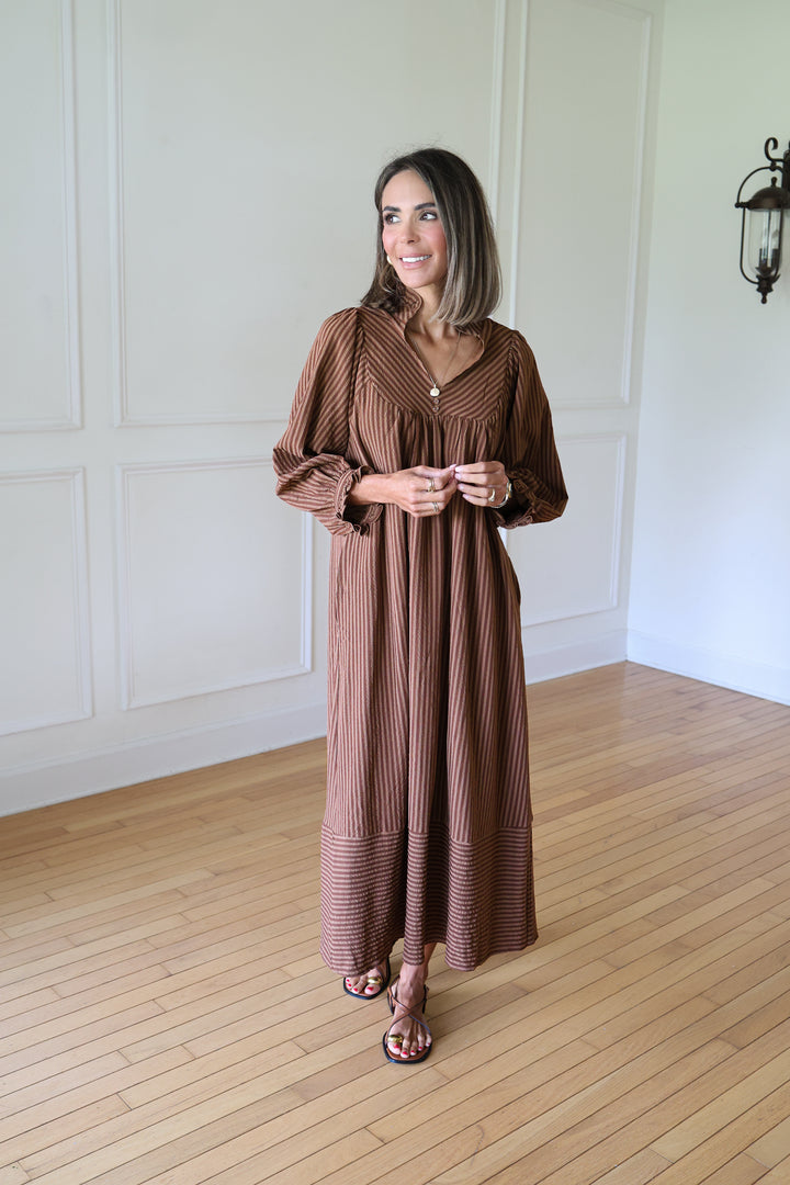 woman wearing brown striped maxi dress