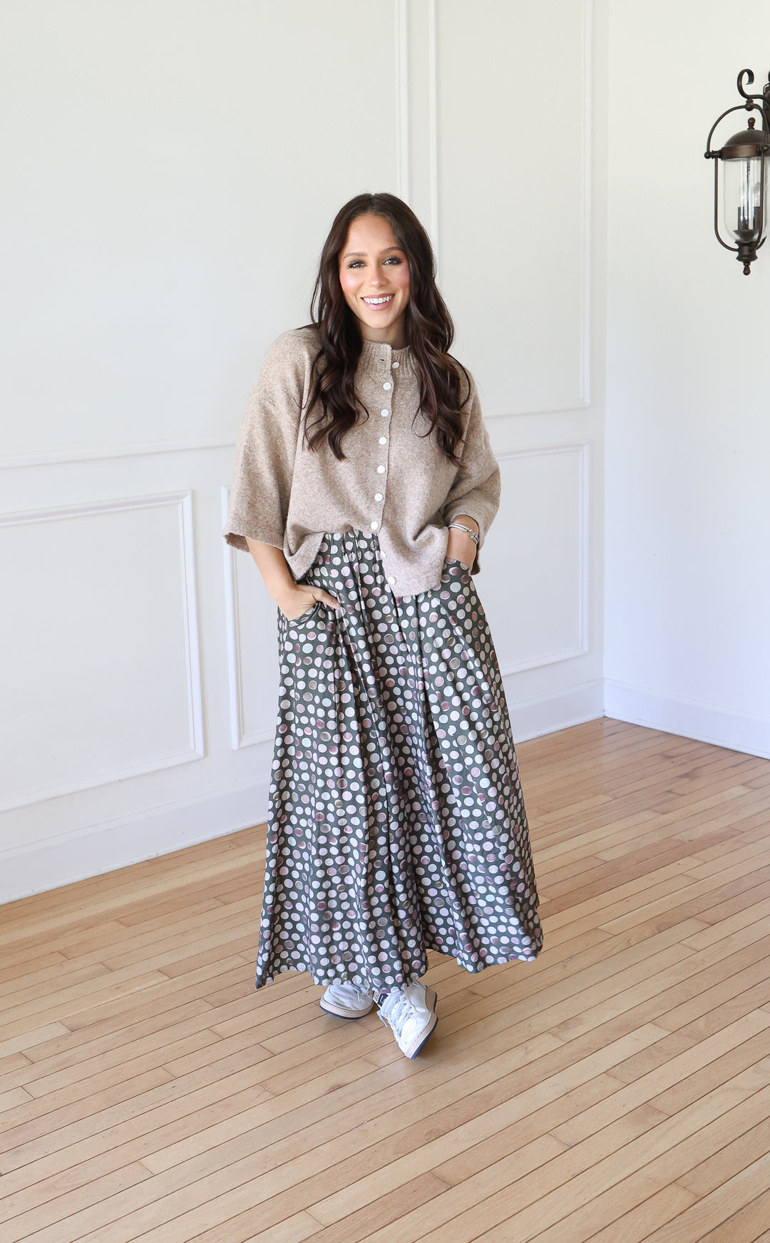 Woman wearing Olive Dot Maxi Skirt with cream cardigan